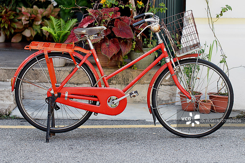 红色老式自行车停在街道上的建筑图片素材