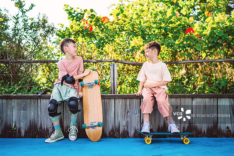 可爱的小弟弟们一起在体育公园玩滑板图片素材