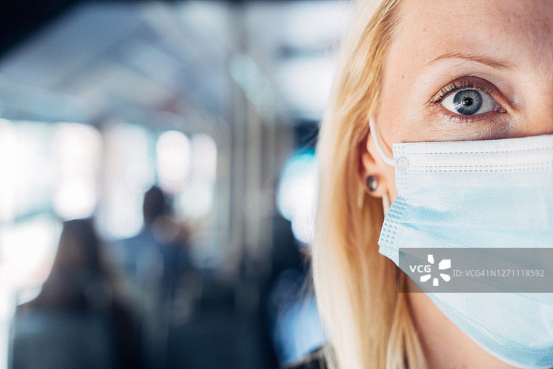 一个女人在地铁里戴着保护面罩的特写图片素材