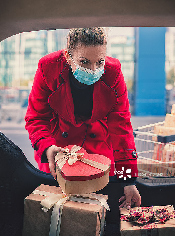 2019冠状病毒病大流行期间，一名年轻女性在圣诞节购物时戴着防护口罩图片素材