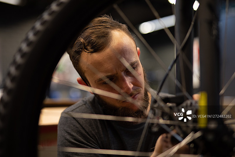 一个自行车修理工在他的车间里。图片素材