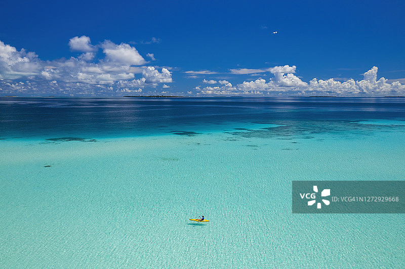 航拍的妇女皮划艇在清澈的热带水域，马尔代夫图片素材