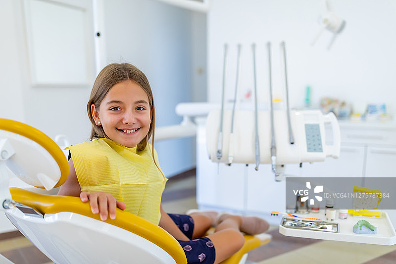 坐在牙医椅上微笑的可爱女孩图片素材