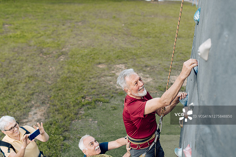 一个老人和一群朋友在尝试运动攀岩图片素材