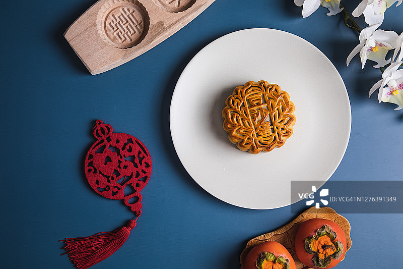 平铺中秋节月饼、饼模、柿子和花装饰图片素材