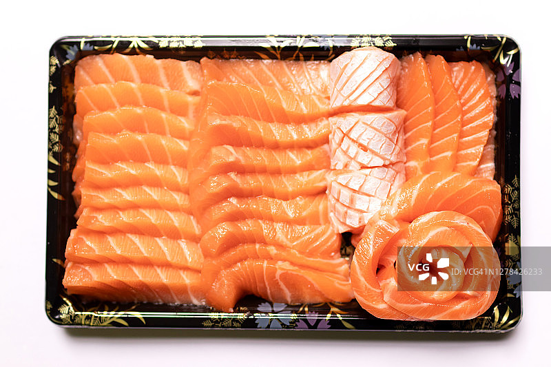 新鲜的鲑鱼生鱼片，以一种方式托盘孤立的白色背景。图片素材