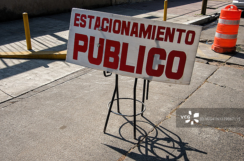市中心道路上的一个凳子上的西班牙语标牌上写着:“Estacionamiento Publico”(公共停车场)图片素材