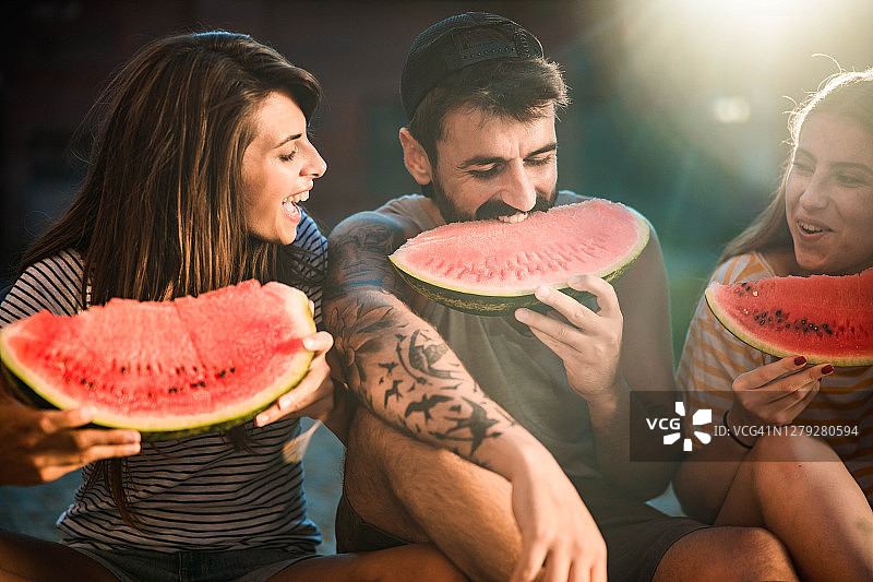 年轻快乐的朋友在吃西瓜。图片素材