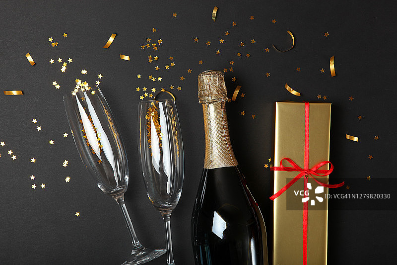 香槟瓶，玻璃和五彩纸屑在一个彩色的背景俯视图。概念假日、生日、圣诞节、新年、庆祝、欢乐。文本。图片素材