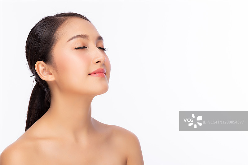 美丽的年轻亚洲女人，皮肤干净清新，闭着眼睛。女性美容面部护理。熊的肩膀。迷人的女孩有美丽的面部皮肤。面部护理、皮肤护理和美容护肤理念图片素材