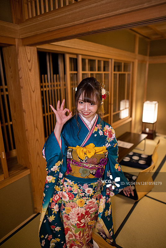 年轻女子在“Furisode”和服享受在日本“ryokan”酒店图片素材