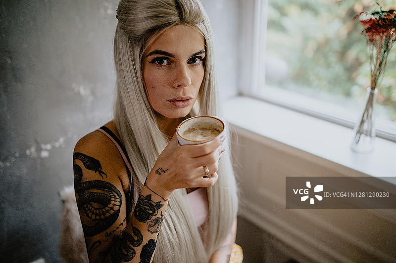 美丽的纹身女人喝浓咖啡图片素材