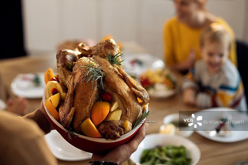 特写的人在餐厅为他的家人服务感恩节火鸡。图片素材