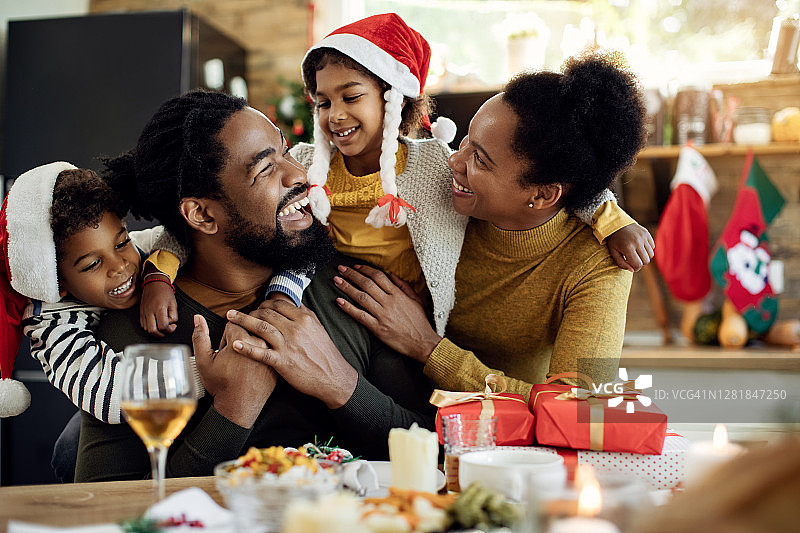 快乐的非裔美国家庭在家里度过圣诞节。图片素材