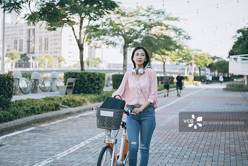 亚洲女性在市中心租用共享单车图片素材