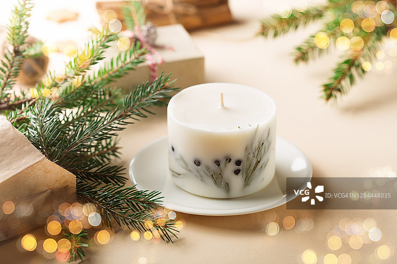 圣诞零浪费环保理念。节日的木制装饰，姜饼饼干，杉木树枝，大豆蜡烛在自然米色背景。图片素材
