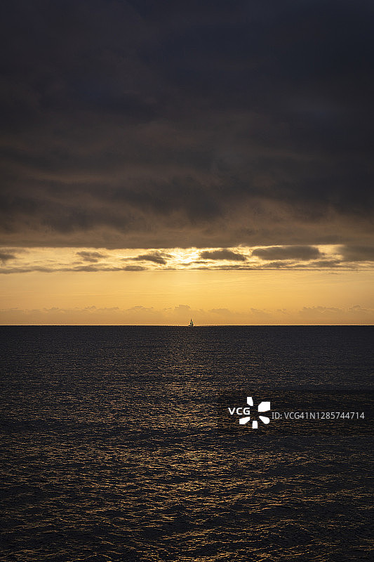 日出时在地平线上航行的小帆船图片素材