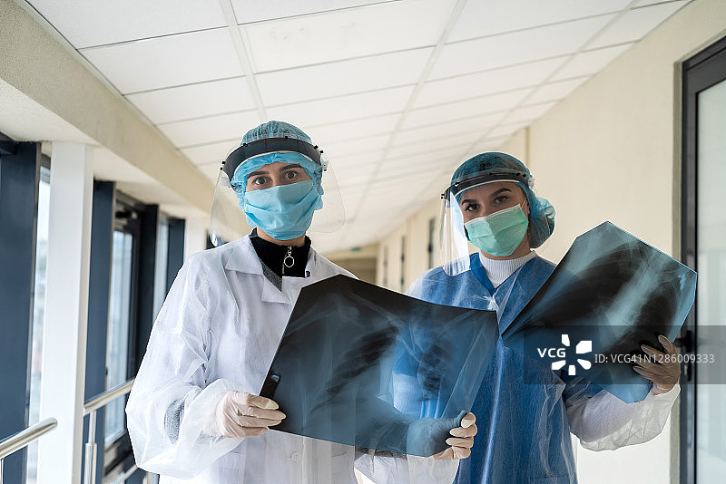 两名女医生在现代诊所看肺部的x光照片。图片素材
