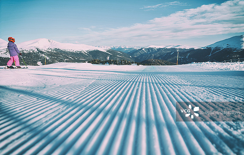 在滑雪胜地，一个小女孩喜欢在山上滑雪。图片素材