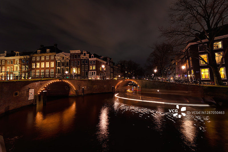 阿姆斯特丹城市拥有美丽的运河、桥梁和房屋。更美丽的是在一个黑暗的夜晚在仲冬图片素材
