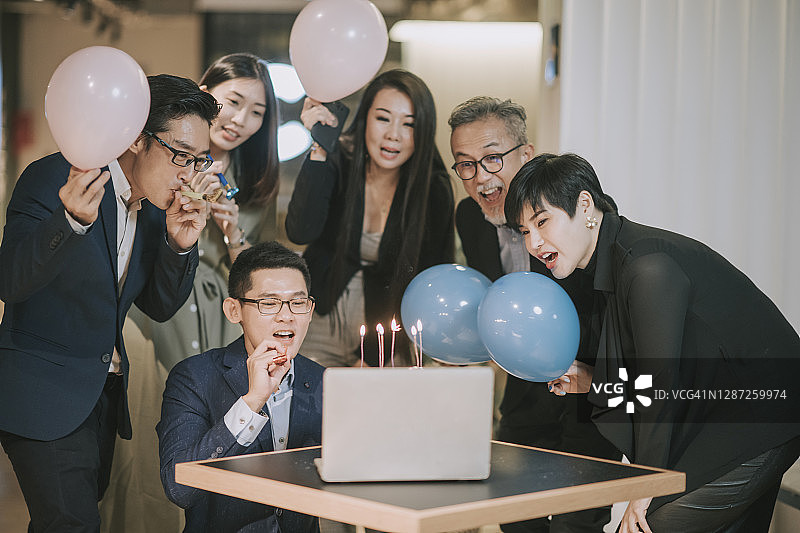 亚洲华人同事组看着笔记本电脑视频会议庆祝生日与他们的同事图片素材