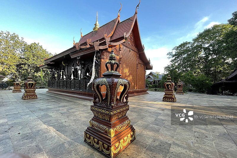 Pong Nam Ron旅游目的地- Wat Khao Chawang寺的木制礼拜堂(外观)，有美丽的木质渴望，大理石佛像和花卉装饰。图片素材