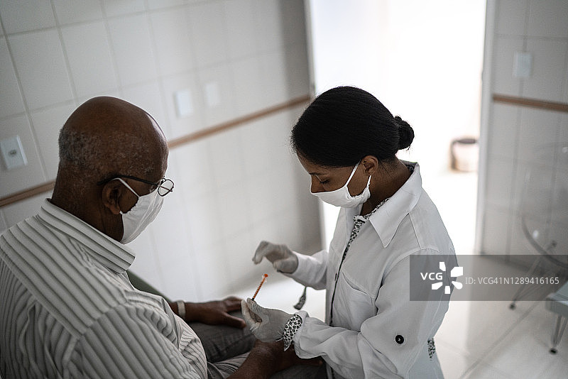 女医生给一个年长的病人注射疫苗图片素材