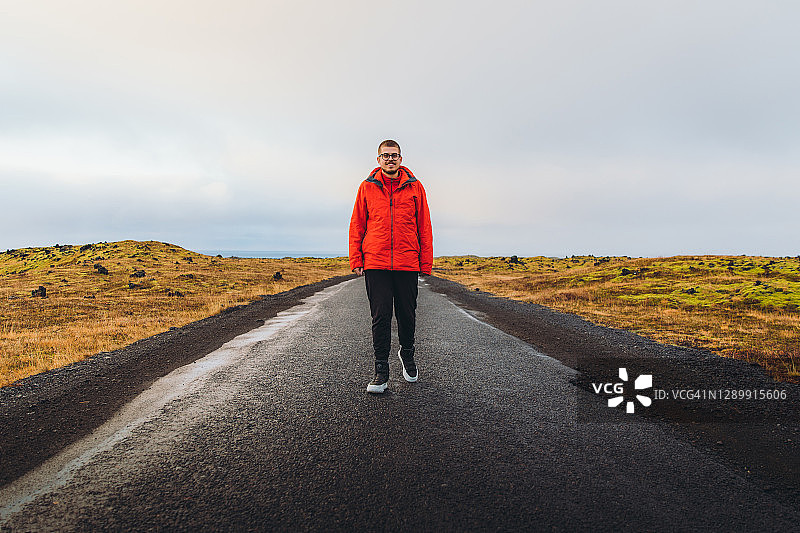 穿着红色夹克的游客探索冰岛的美丽图片素材