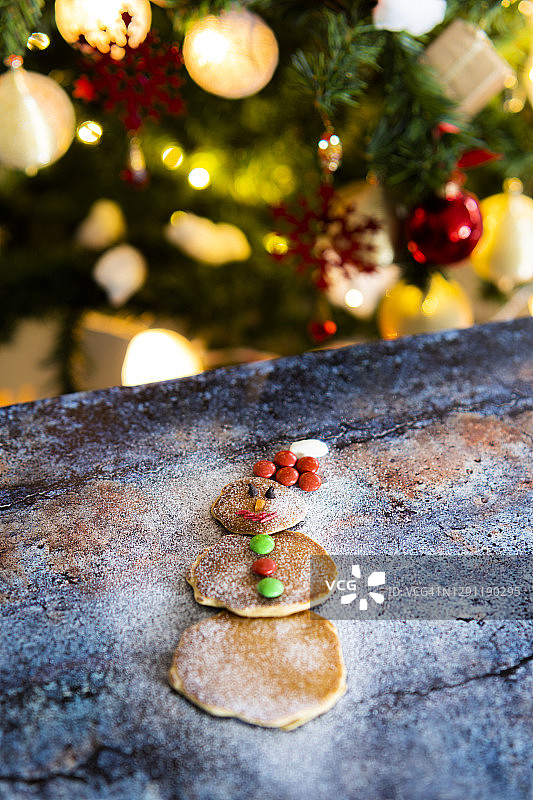 雪人形状的煎饼和圣诞树灯图片素材