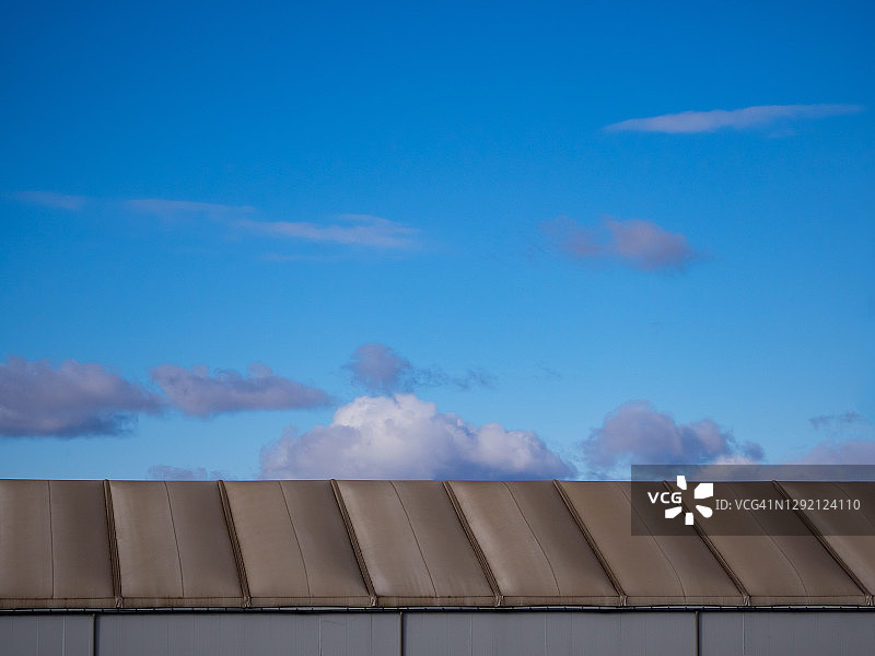 屋顶的最小工业几何图案，背景是蓝天和白云图片素材