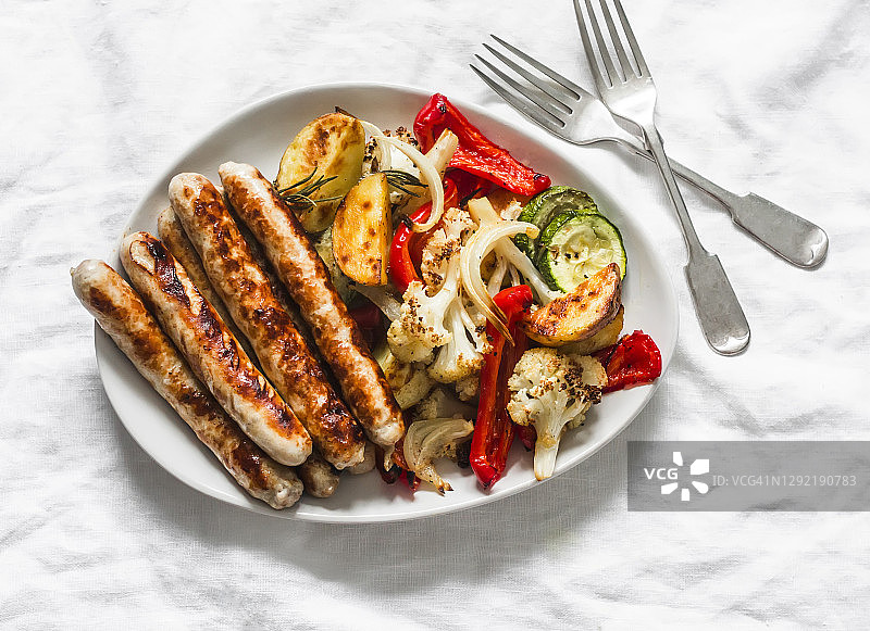 烤火鸡香肠和烤蔬菜在一个较轻的背景，俯视图。美味的午餐，小吃，开胃菜图片素材