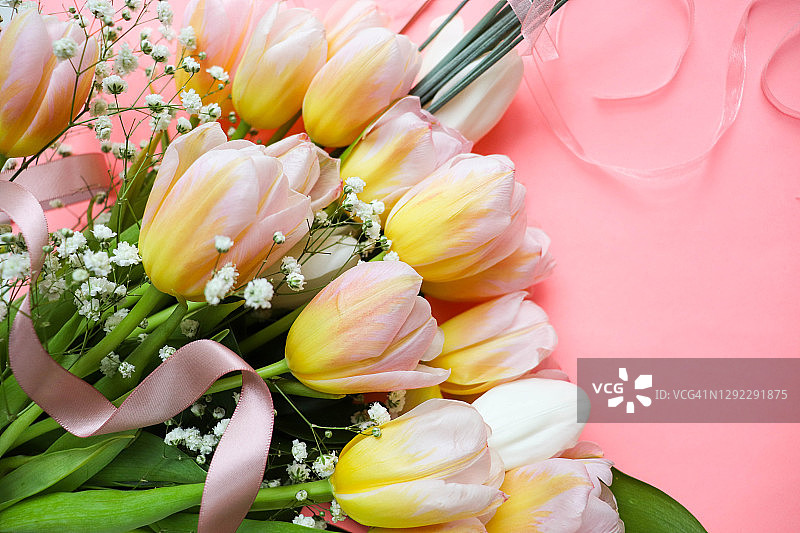 明信片的布局。粉红色背景和文字空间上的春天郁金香花束图片素材