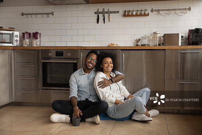微笑的混血儿夫妇在厨房放松的肖像图片素材
