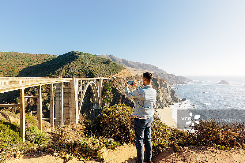 美国加州，游客用智能手机拍摄比克斯比溪桥图片素材
