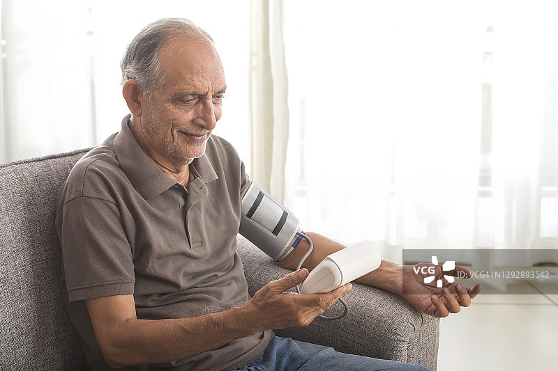 一个老人在家里测血压。(健康)图片素材