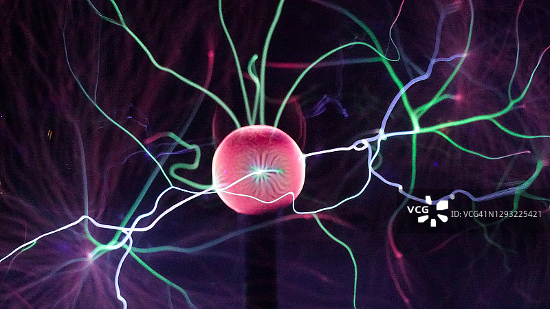 等离子球灯近距离，电子射线从球上的黑色背景。特斯拉线圈实验用电。美丽的动态抽象光背景的颜色。图片素材
