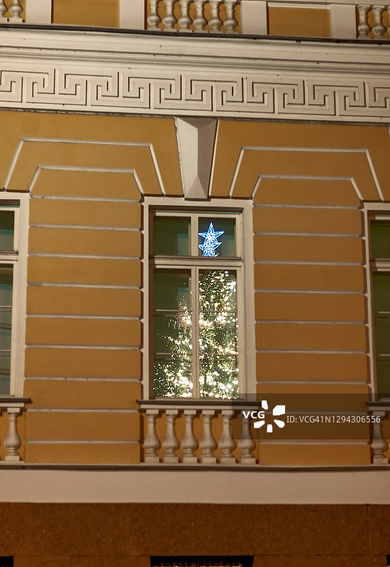 俄罗斯圣彼得堡宫广场上一棵圣诞树在房子窗户上的倒影图片素材