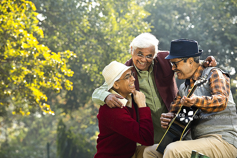 三个老人在公园玩吉他，玩得很开心图片素材