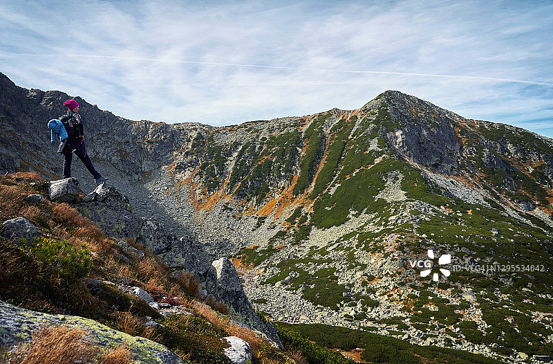 女徒步者在岩石山顶俯瞰山顶全景，欣赏喀尔巴阡山脉的景色。图片素材