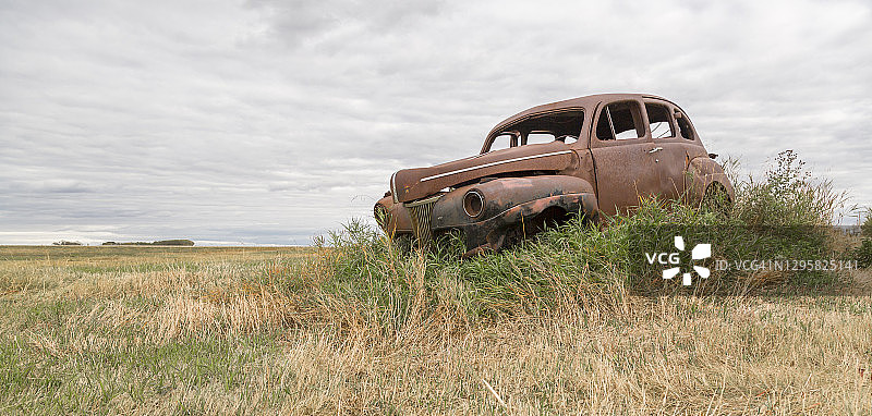 一辆老爷车停在废弃农场的旧车道上图片素材