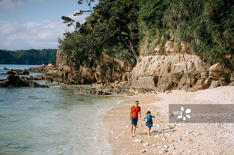 父亲和孩子在日本的海滩上散步图片素材