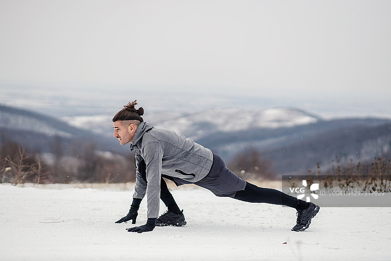 使运动员处于出发位置。运动员在下雪的大自然中锻炼身体。大自然，户外健身，冬季健身图片素材