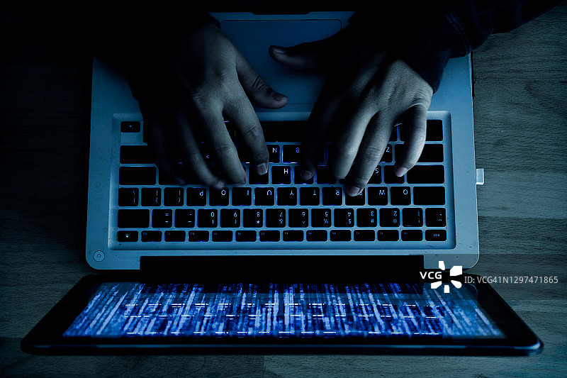 计算机程序员或黑客在笔记本电脑的键盘上打印一个密码，进入一个秘密的组织系统。网络犯罪的概念。图片素材