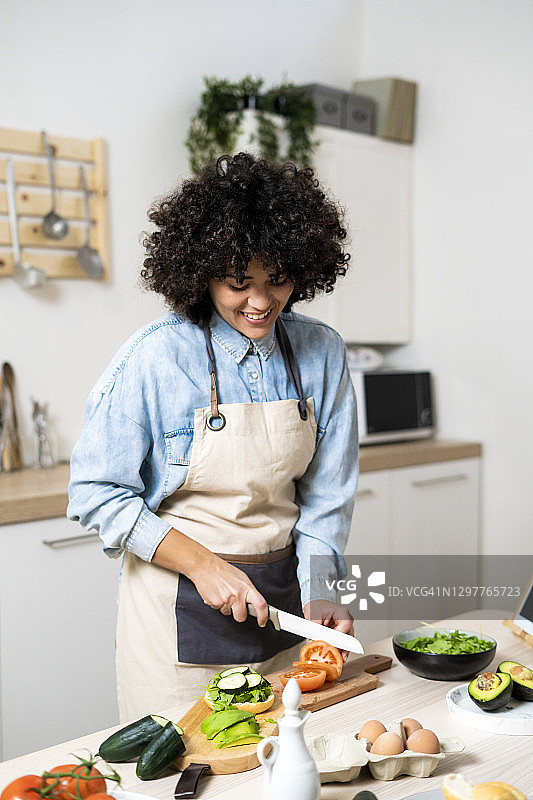 年轻女子在厨房切菜的肖像图片素材