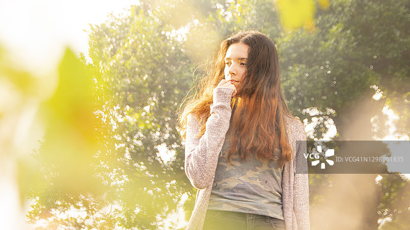 年轻女子的肖像在树叶和雾之间的背景图片素材