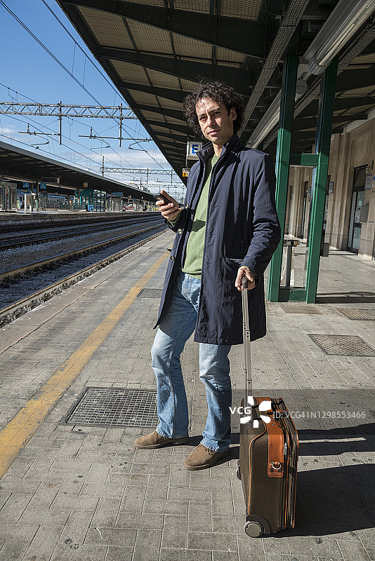 一个年轻人在火车站等火车图片素材