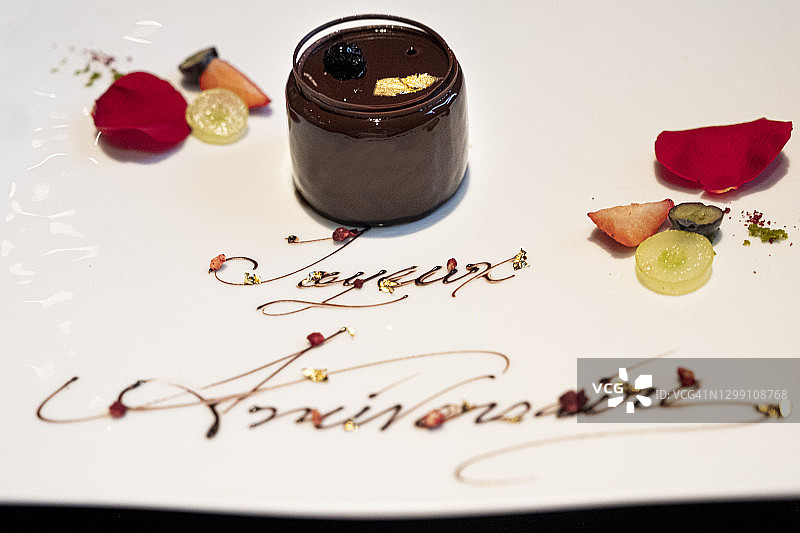 一个用文字和玫瑰装饰的巧克力生日蛋糕图片素材