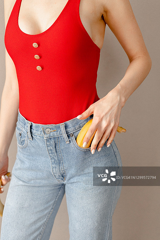 女人摸着牛仔裤口袋里的香蕉图片素材