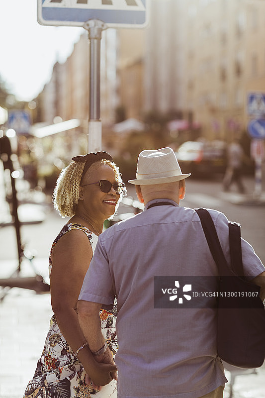 在假期探索城市的时候，微笑的女人看着老男人图片素材