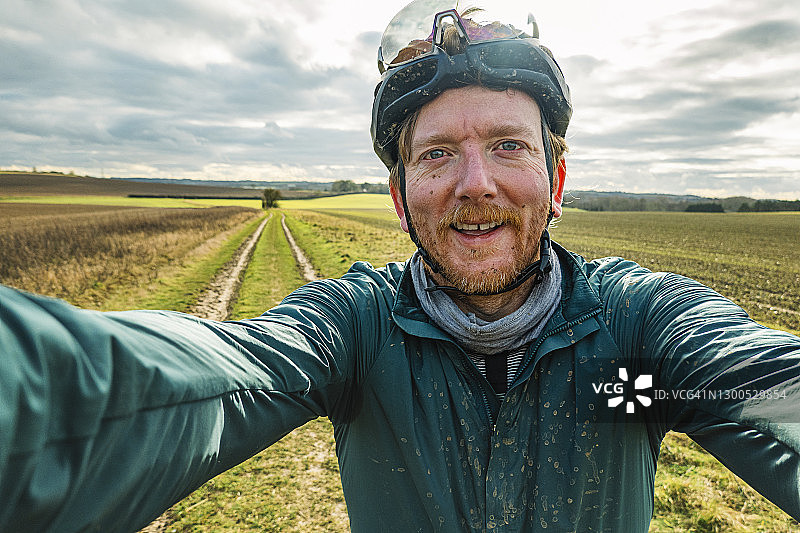 快乐的自行车手在乡村轨道上自拍图片素材